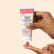 Personne qui tient un gommage visage Aroma-Zone