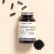 Complément alimentaire Charbon actif Aroma-Zone sur fond beige avec des gélules et de la poudre