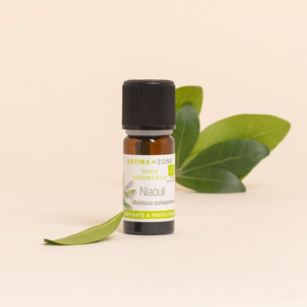 Huile essentielle de niaouli Aroma-Zone avec feuille sur fond beige