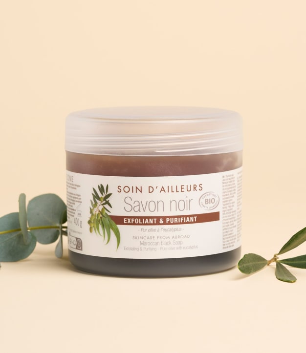 Savon noir Aroma-Zone avec feuilles sur fond beige