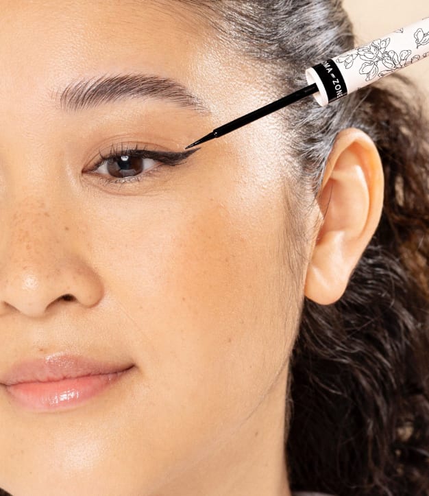 Femme appliquant de l'eye liner noir
