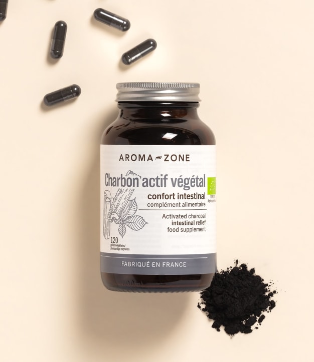 Complément alimentaire Charbon actif Aroma-Zone sur fond beige avec des gélules et de la poudre
