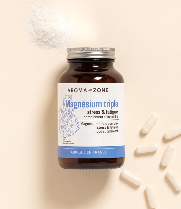 Complément alimentaire Magnésium Aroma-Zone sur fond beige avec des gélules et de la poudre blanche