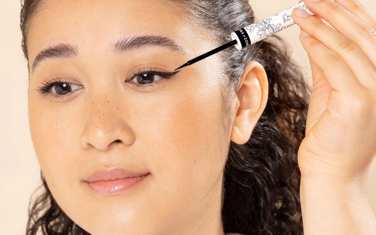 Femme appliquant de l'eye liner noir