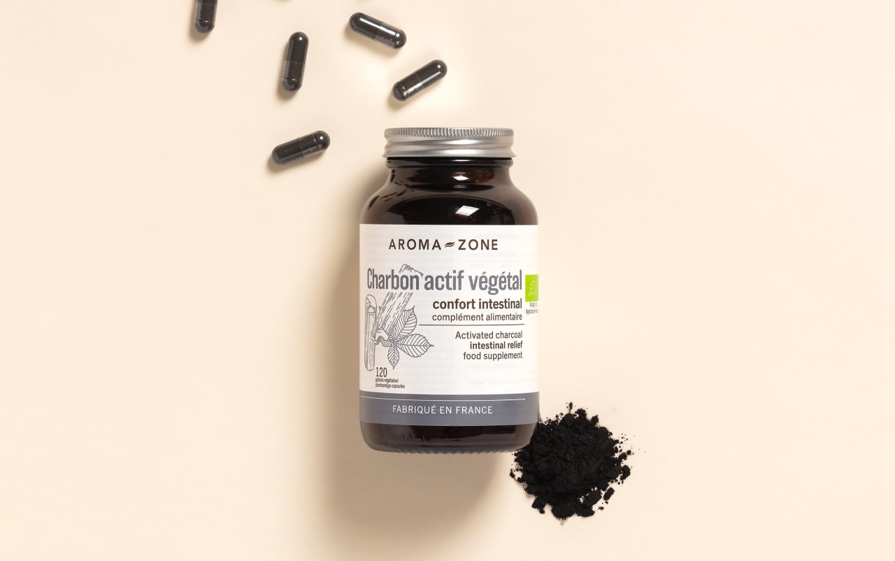 Complément alimentaire Charbon actif Aroma-Zone sur fond beige avec des gélules et de la poudre