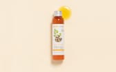 Huile de Moringa Aroma-Zone sur fond beige avec une goutte d'huile