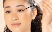 Femme appliquant de l'eye liner noir