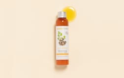 Huile de Moringa Aroma-Zone sur fond beige avec une goutte d'huile