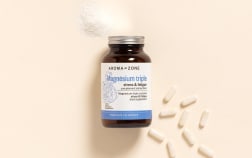 Complément alimentaire Magnésium Aroma-Zone sur fond beige avec des gélules et de la poudre blanche